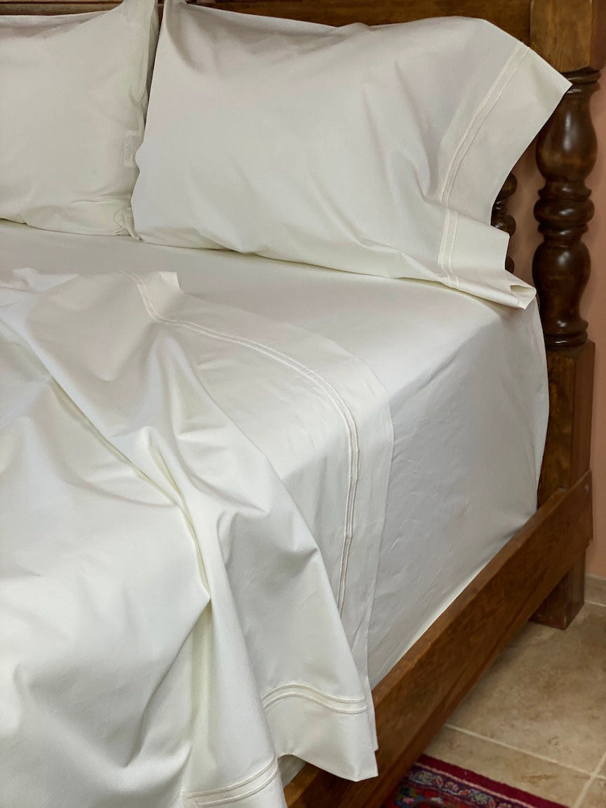 Ivory sheets embroidered with double rows of satin stitch in "Ivory" color.